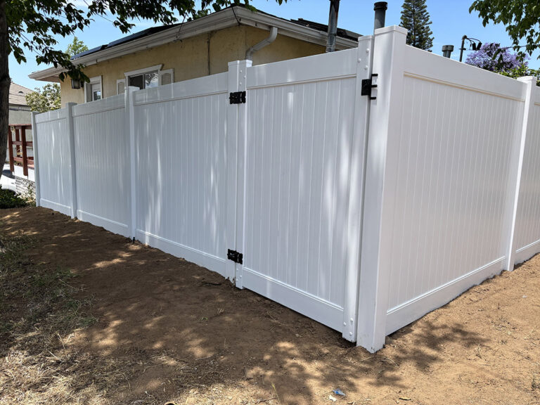 Solid white vinyl privacy fence along a property boundary
